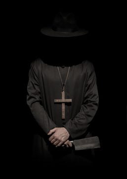 standing person wearing hat and cross necklace holding cleaver